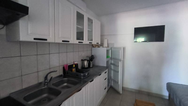 A kitchen in a family house with white cabinets, a stove, and a refrigerator.