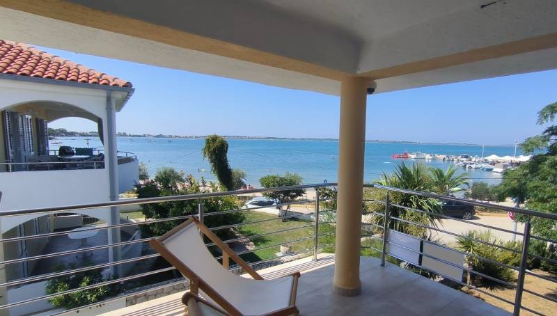 View from a family house in Vrsi of the sea and harbor with greenery.