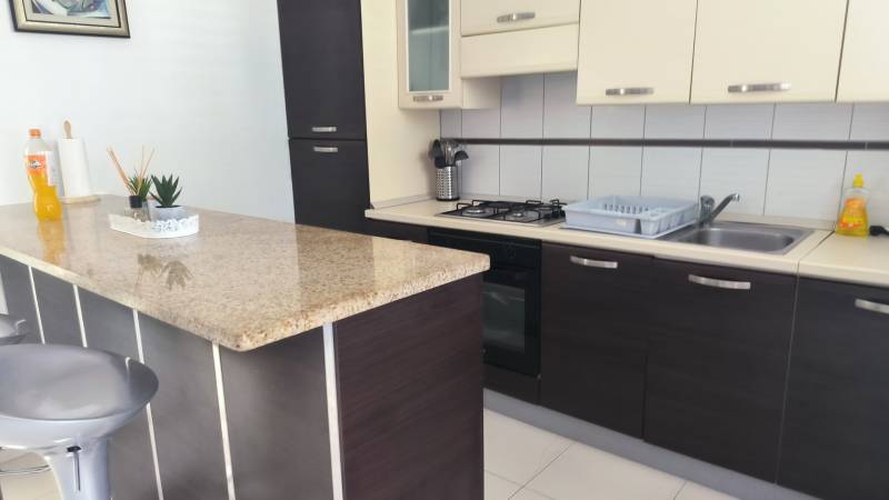 A kitchen in a family house with a kitchen unit, a bar counter, and built-in appliances.