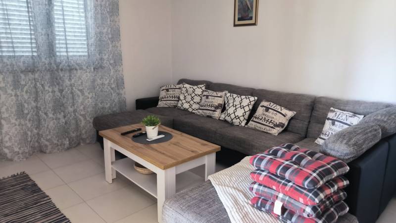 Comfortable corner sofa with cushions in the living room of a family house.