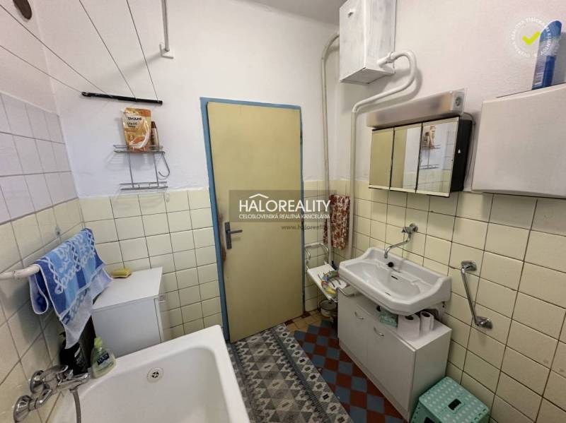 Bathroom in a family house with a sink, bathtub, and storage space.