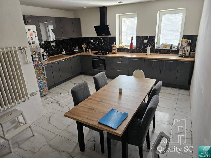 A kitchen in a family house with modern equipment and a large table for six people.