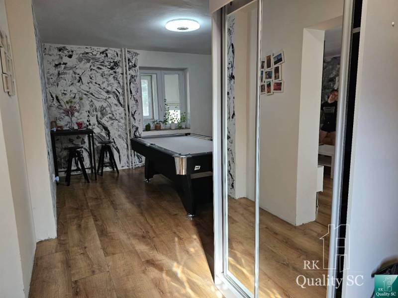 Interior of a family house with a billiard table, table and chairs, wooden floor.