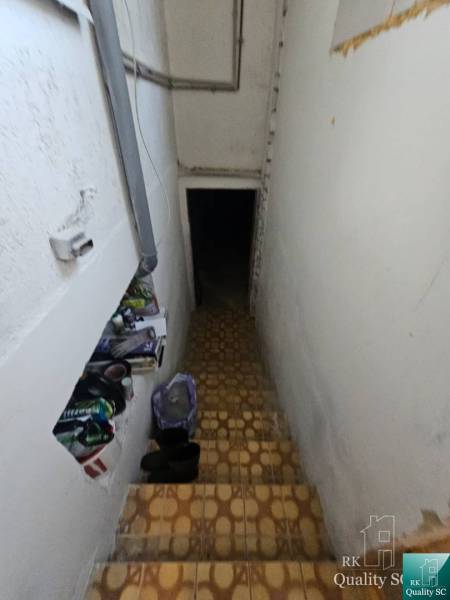 The staircase leads to the basement in the family house, and there are things placed on the stairs.