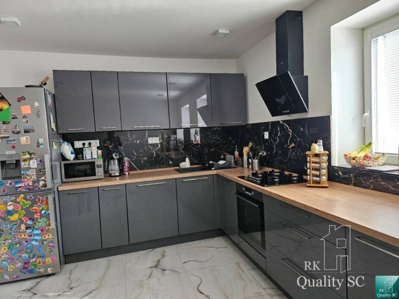 A kitchen in a family house with dark cabinets, appliances, and a decorative magnetic refrigerator.