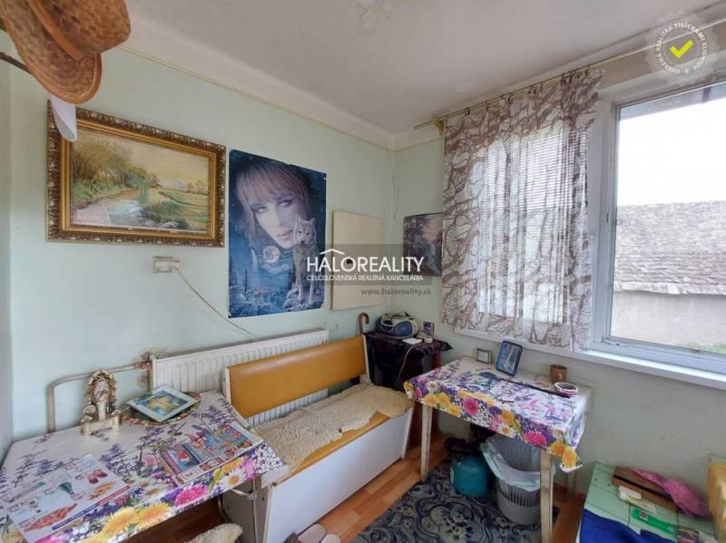 Placement of a table and chairs by the window in a family house with decorations and paintings.