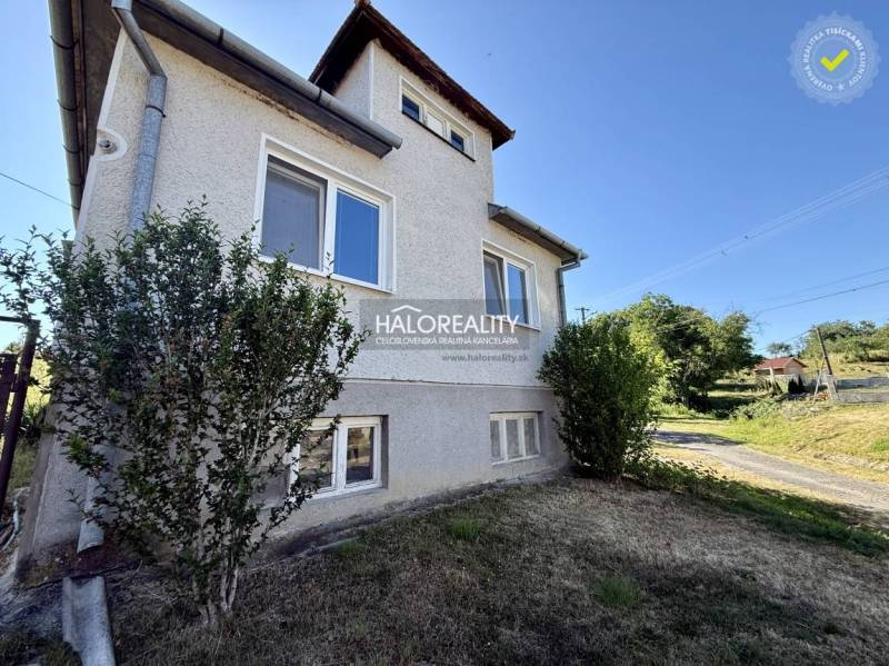 A family house in Padarovce with two floors near a garden and a road, surrounded by greenery.