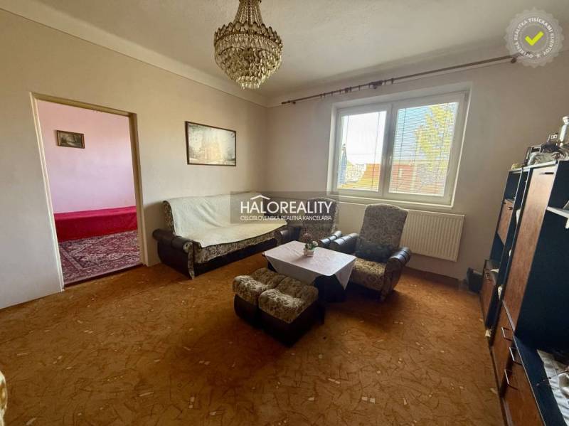 Living room of a family house with a sofa, armchairs, and a chandelier.
