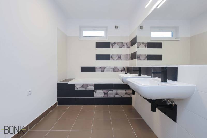 A bathroom with two sinks and a bathtub in a 3-room apartment.
