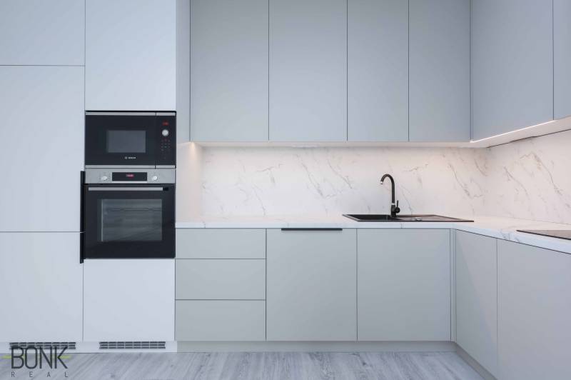 A kitchen unit in a family house with a sink, stove, and built-in oven.