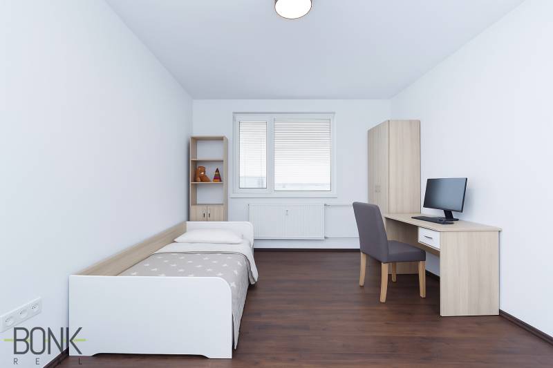 A simple room with a bed, a desk, and a shelving unit in a 3-room apartment.