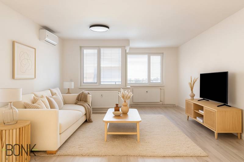 Living room in a 3-room apartment with a beige couch, a table, and a television on a stand.