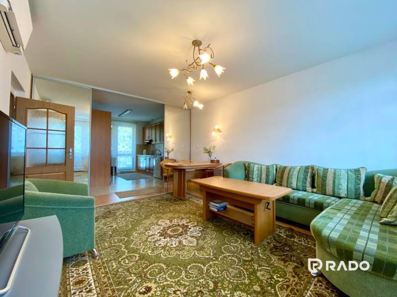 Living room with a comfortable sofa and a dining table in a 3-room apartment.