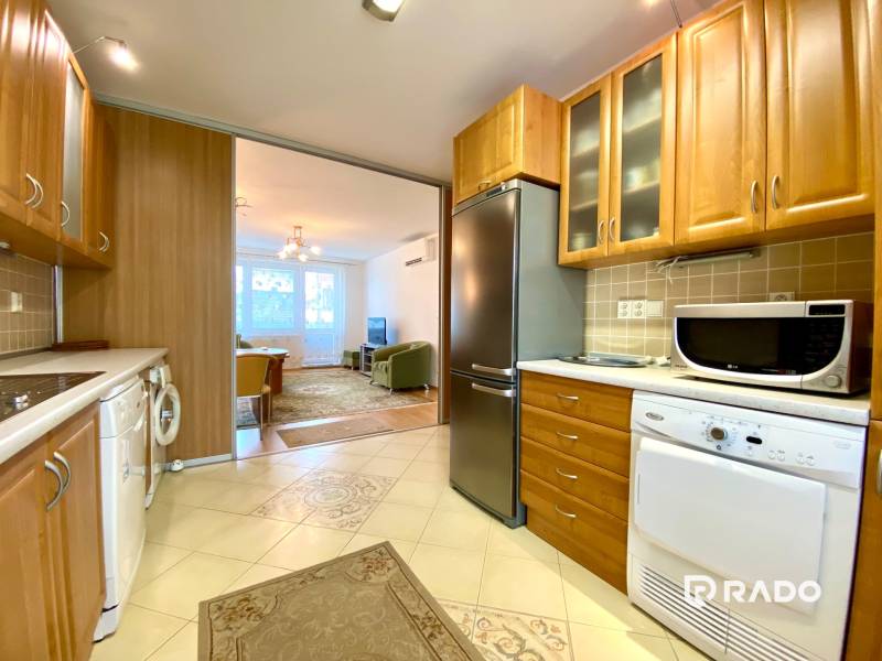 A kitchen in a 3-room apartment with wooden furniture and built-in appliances.
