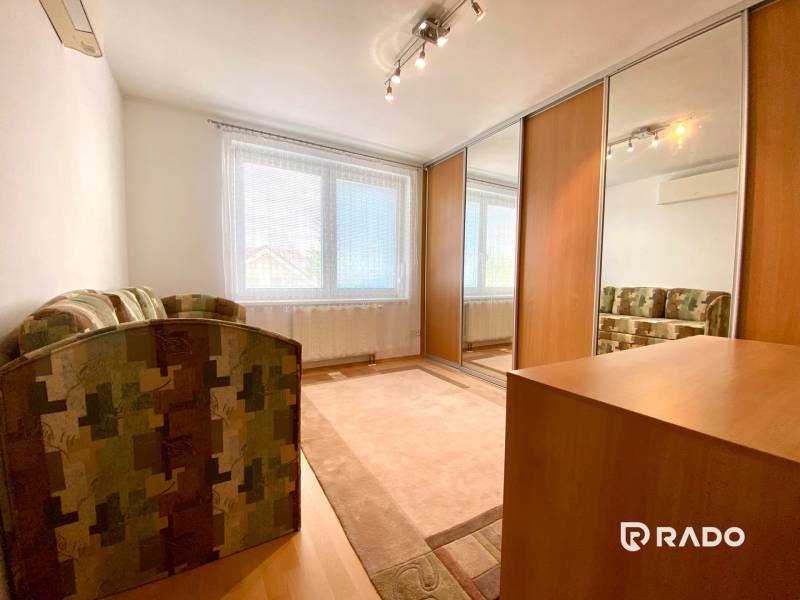 Interior of a room with a sofa, built-in wardrobe, and window in a 3-room apartment.
