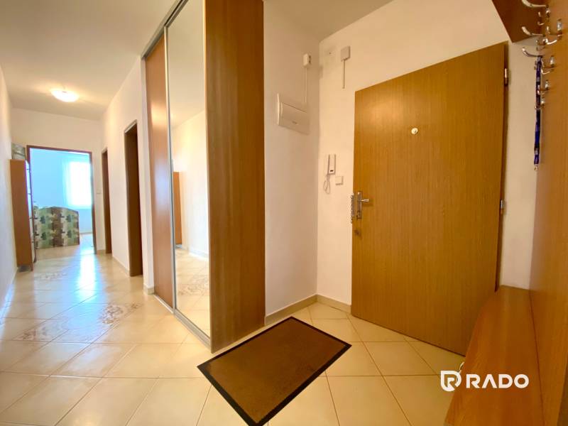 A hallway with ceramic tiles and a built-in wardrobe in a 3-room apartment.