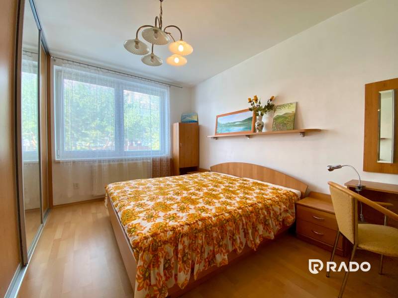 Bedroom in a 3-room apartment with a large window, bed, and built-in wardrobe.