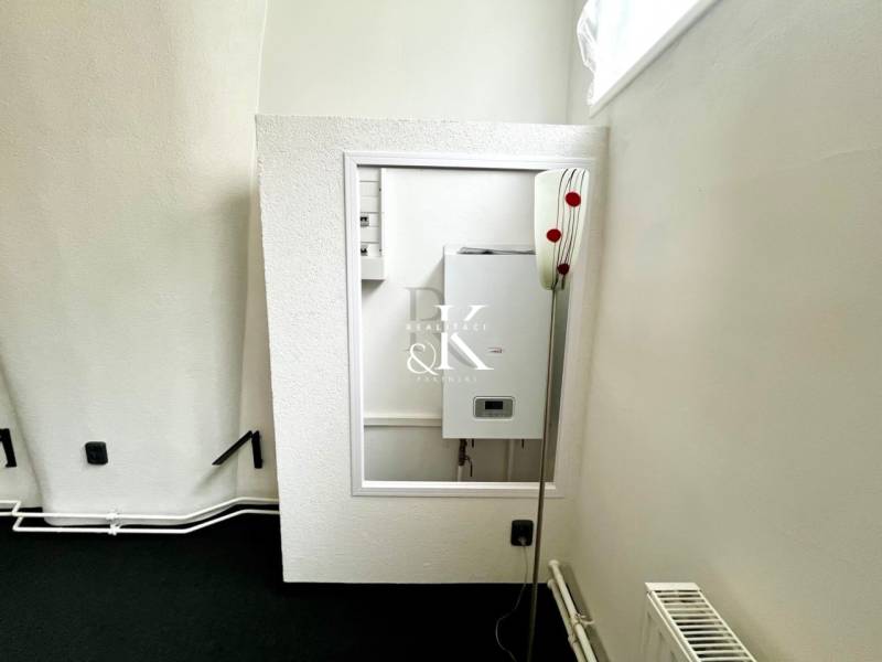 A corner with a boiler, radiator, and electrical connection in commercial premises.