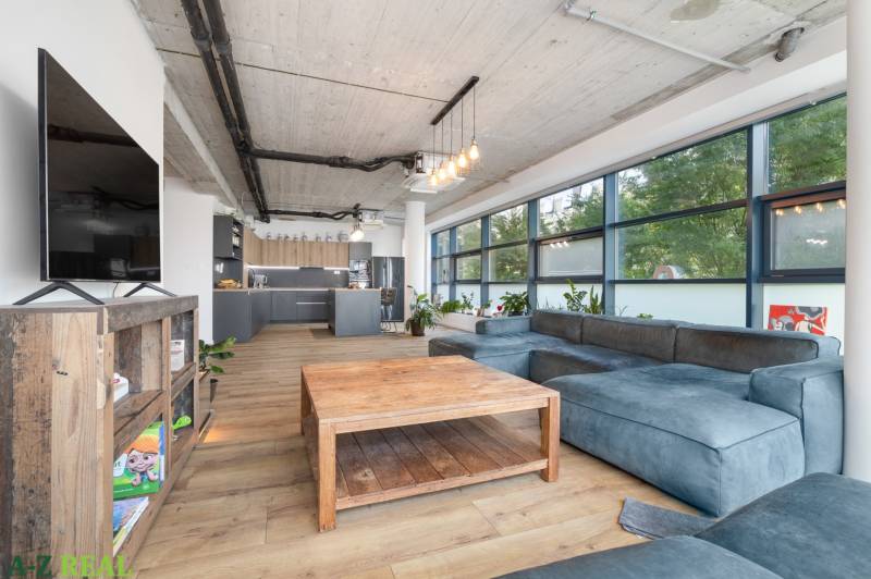 Living room in a 4-room apartment with a large sofa and a wooden table.