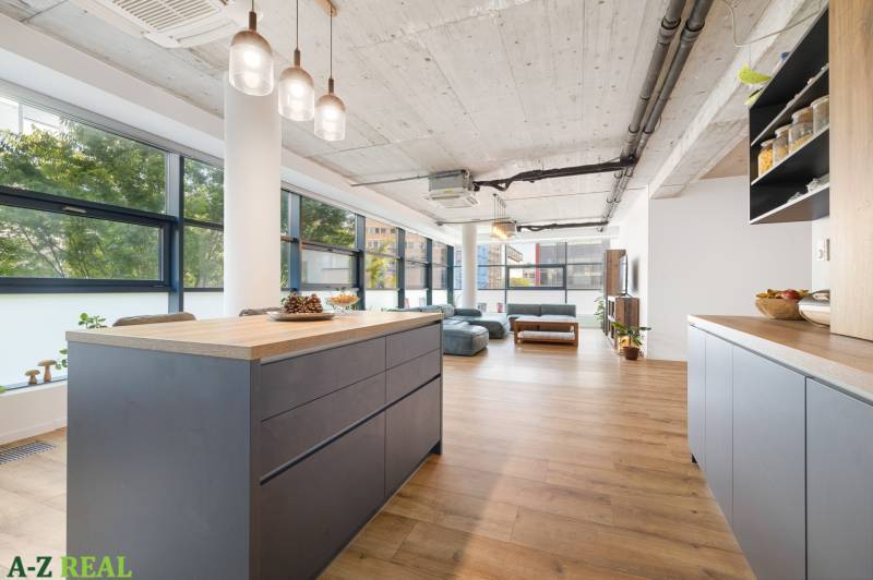A kitchen with an island in a spacious 4-room apartment with wooden floors.