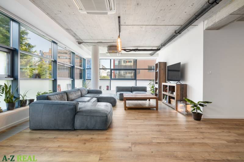 Interior of a 4-room apartment with a spacious living room, large windows, and comfortable seating.