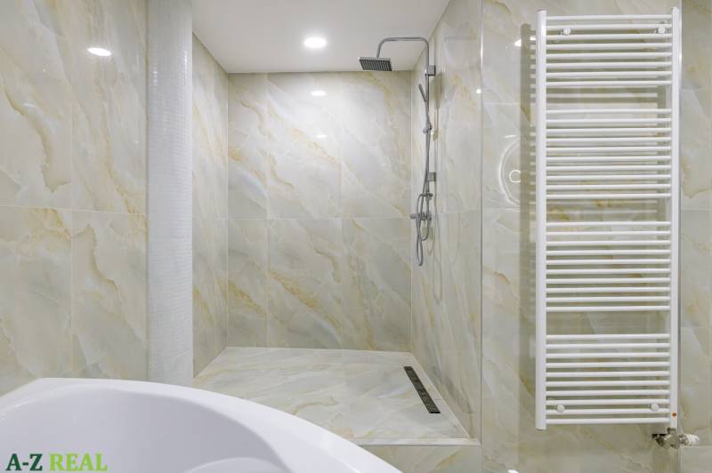 A bathroom with a shower and a radiator in a 4-room apartment.
