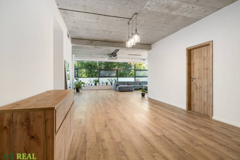 A bright hallway in a 4-room apartment with wooden flooring and large windows.