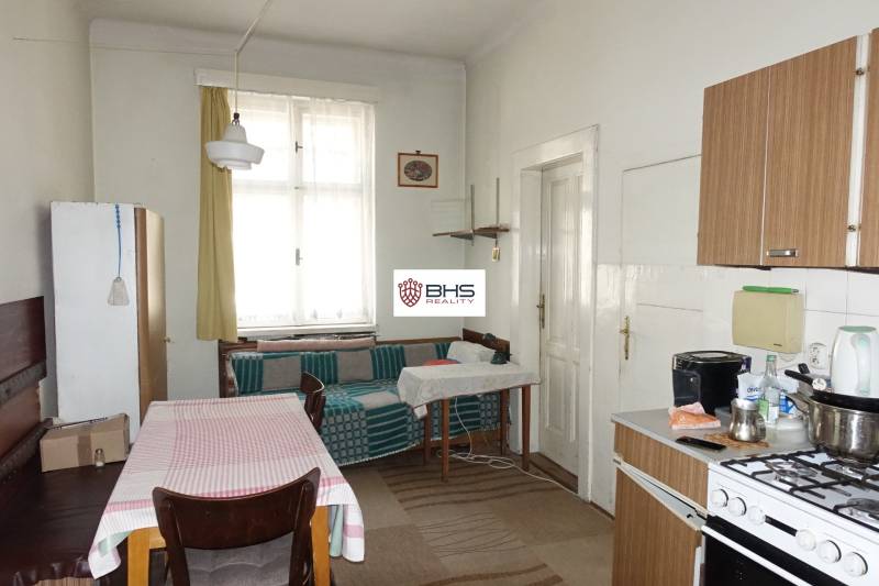 Kitchen in a family house with a dining table, stove, and sofa.