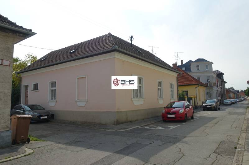 A family house on Hviezdoslavova Street in Piešťany. Pink plaster, cars parked next to it.