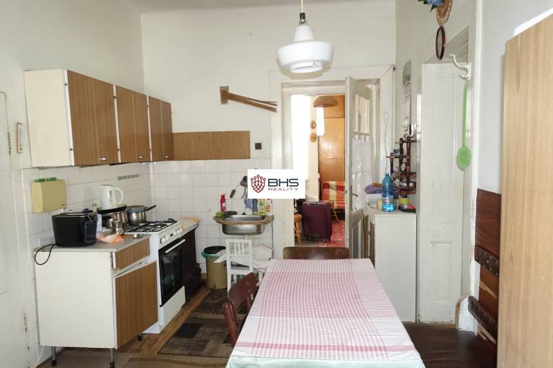 Kitchen in a family house with a dining table, stove, and cabinets.