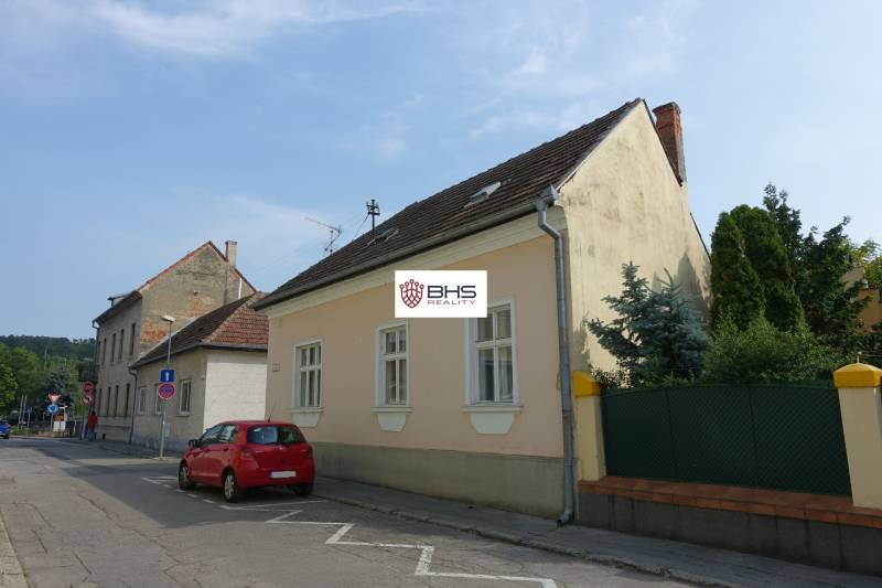 A family house on Hviezdoslavova Street in Piešťany, with a red car parked by the road.