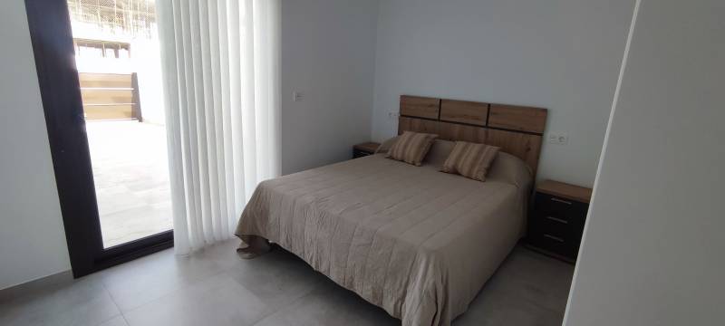 Bedroom in a 4-room apartment with a double bed and a window to the terrace.