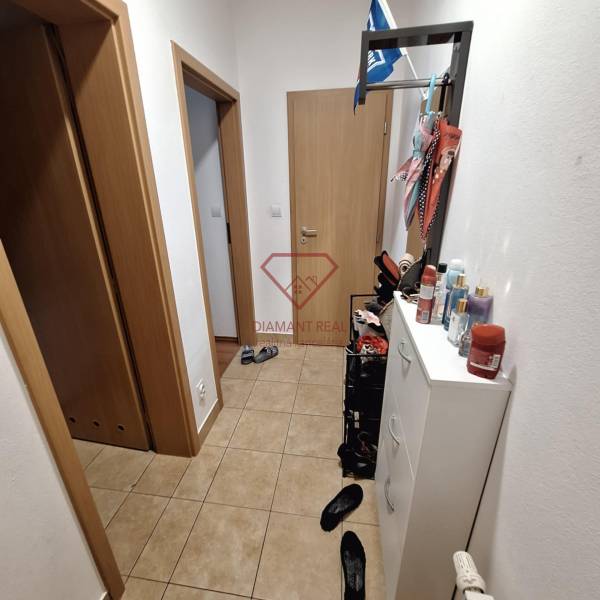 A narrow hallway with a shoe cabinet and doors in a 3-room apartment, suitable storage solution.