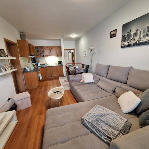 Living room with a kitchen in a 3-room apartment with a comfortable sofa and a dining table.