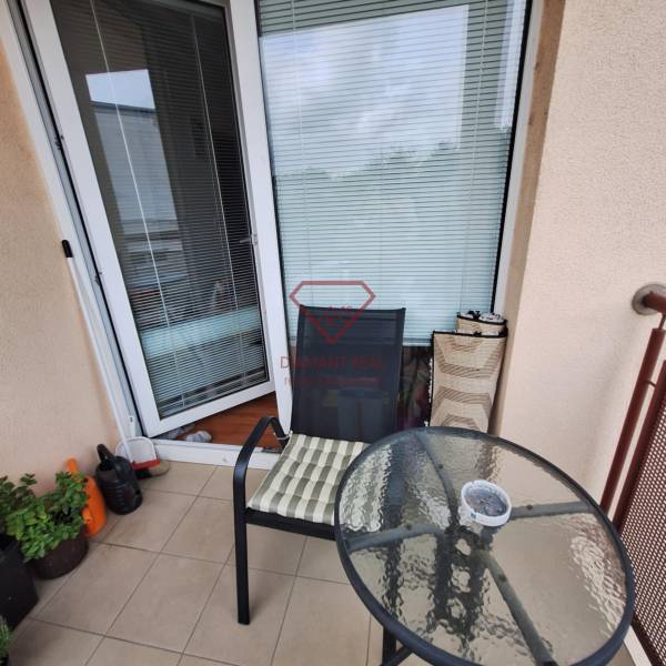 A small balcony with a round table and a chair in a 3-room apartment.