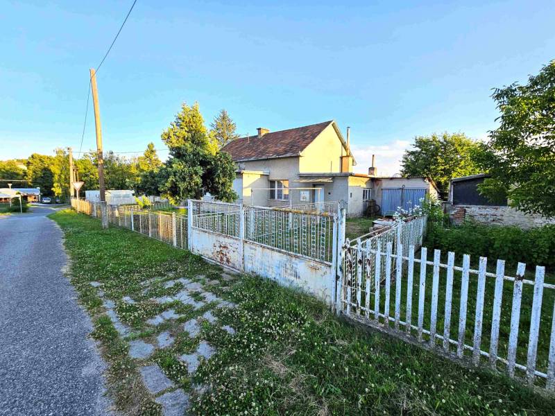 A family house in Kuzmice with a fence and a garden, next to a quiet street.