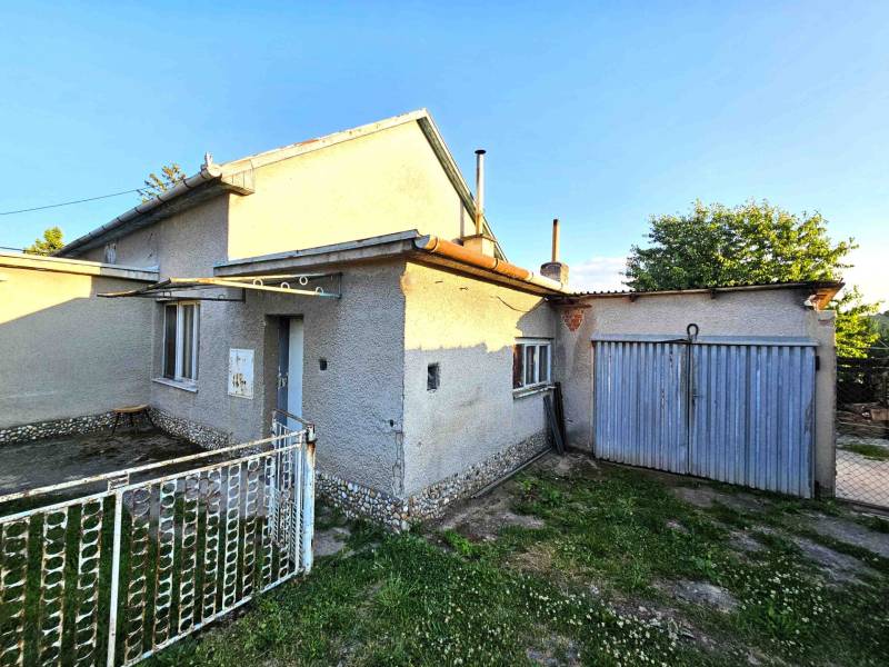 A family house in Kuzmice with a garage, front garden, and a blue gate.