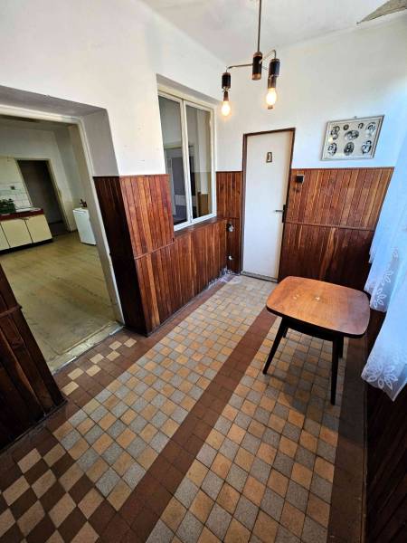 Interior of a family house with patterned flooring, doors, and wooden wall paneling.