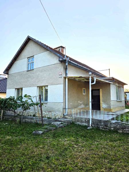 A family house in Kuzmice with a grassy garden and a gentle slope.