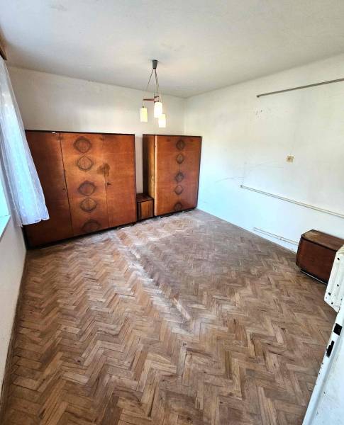 A room in a family house with a wooden floor and older furniture.