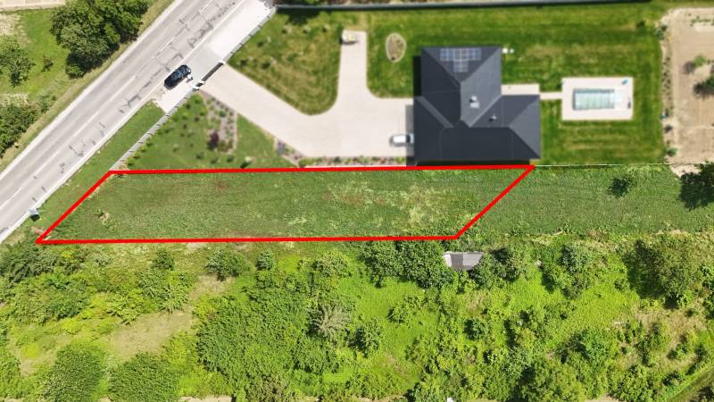 A plot for residential use in Nové Mesto nad Váhom next to the road, bordered by a red line.
