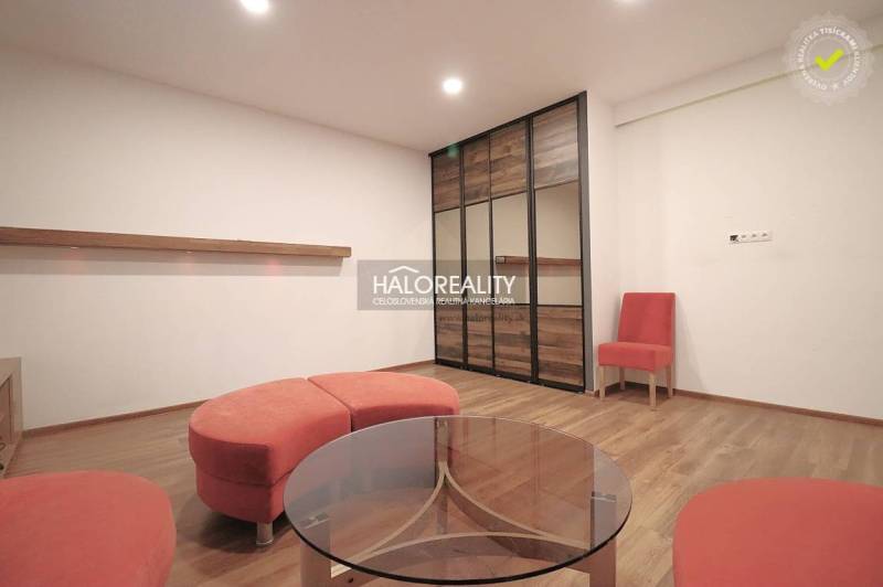 A room with a wooden floor, orange furniture, and a glass table, ideal for family living.