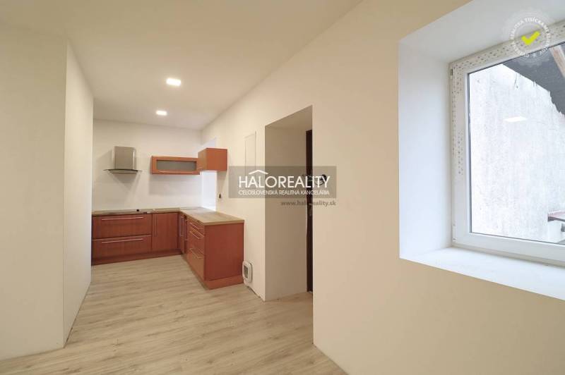 A kitchen with wooden cabinets and laminate flooring in a family house for sale.