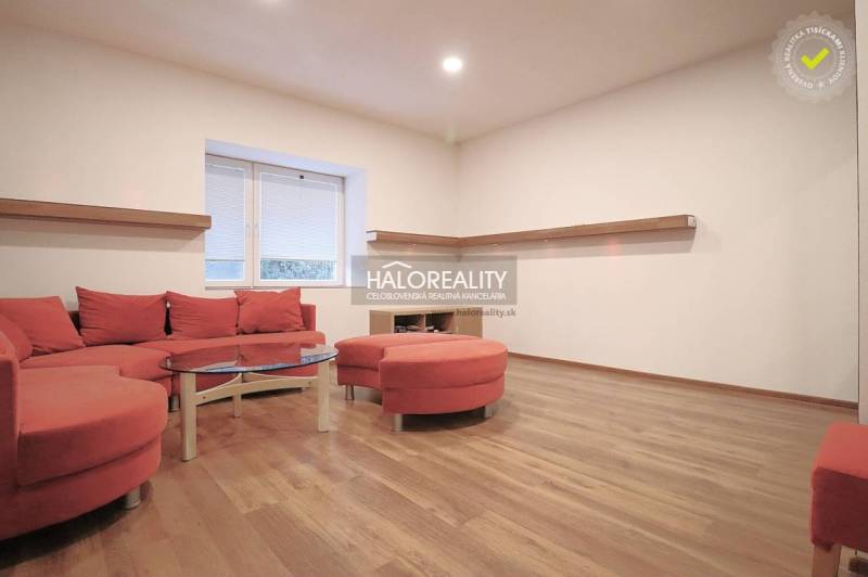 Living room of a family house with a red sofa set and wooden flooring.