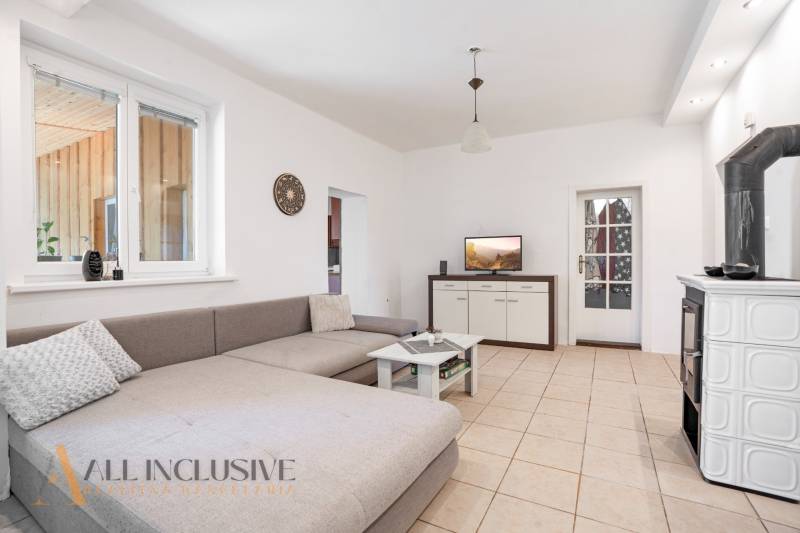Living room in a family house with a gray sofa, table, and fireplace.