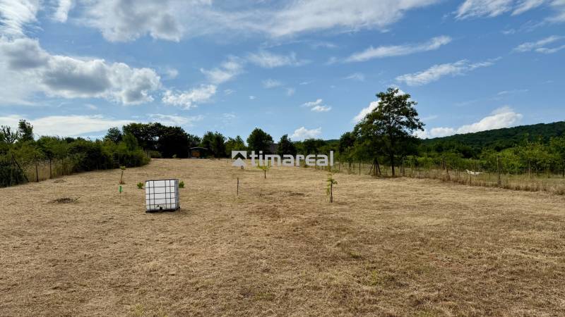 Extensive agricultural and forest lands on Sadová Street in Limbach with a water reservoir.
