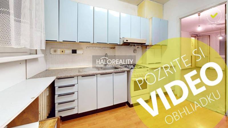 A kitchen in a 3-room apartment with blue cabinets, wooden flooring, and a gas stove.