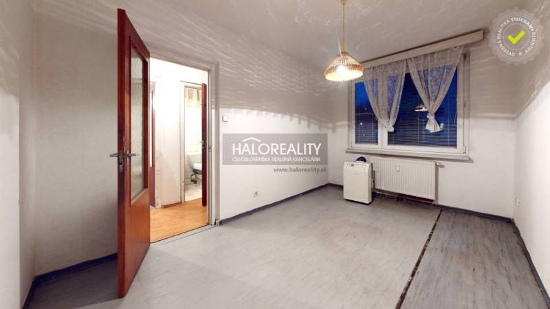 An empty room with wooden doors, a plastic window, and a curtain in a 3-room apartment.
