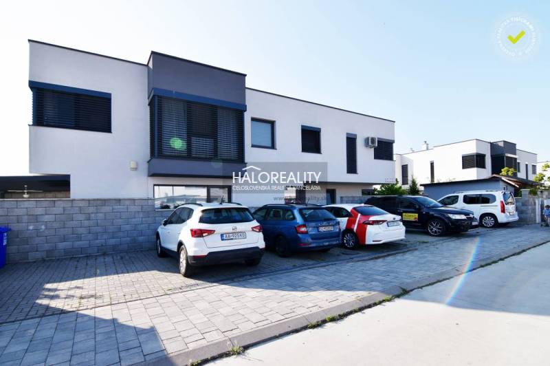 A family house in Rovinka with parking and a modern facade, surrounded by cars.