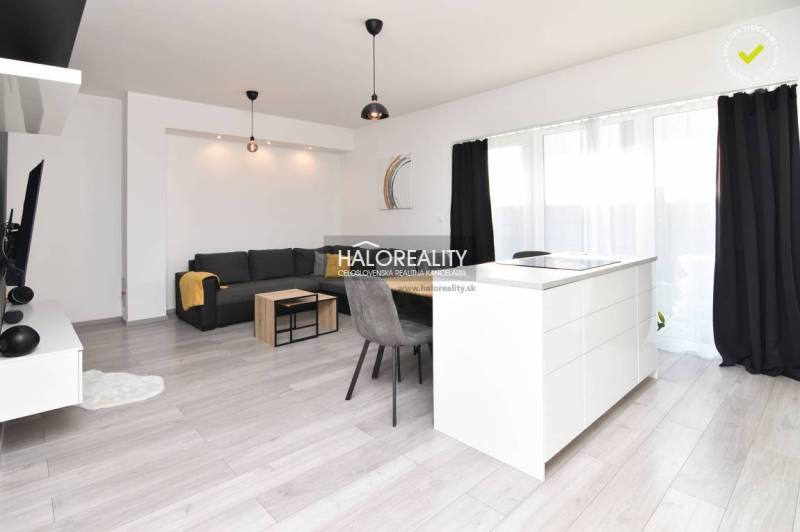 Living room in a family house with a kitchen island, sofa, and dining table.